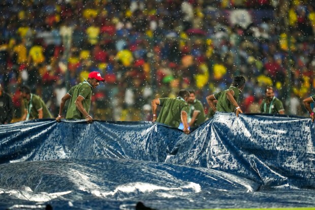 Ground staff is seen covering the pitch at Chinnaswamy. May 18th holds significance for the Challengers and Virat Kohli. RCB has never lost a T20 match on this date in the IPL, winning four, including a couple against CSK. (PTI Photo)