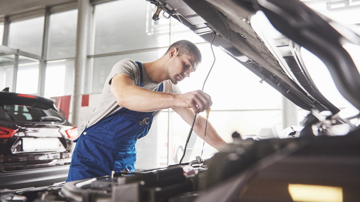 Auto mechanic working in garage. Repair service.