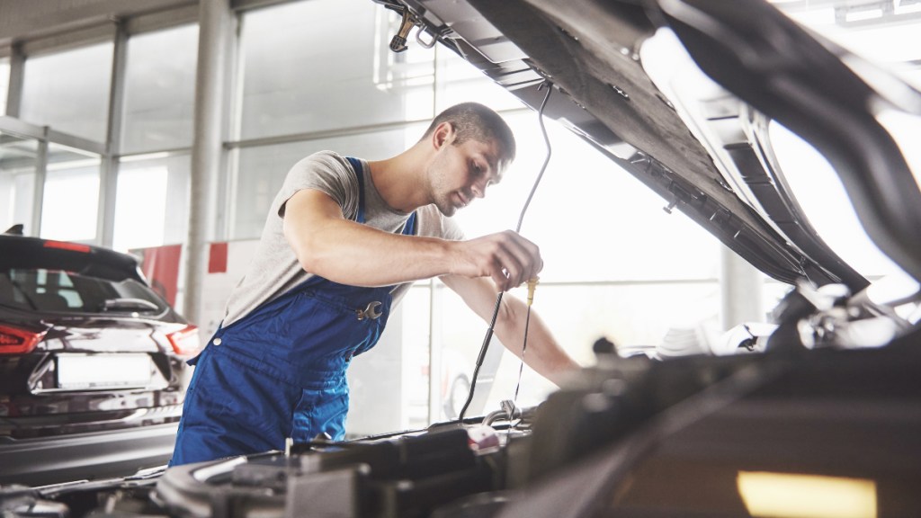 Auto mechanic working in garage. Repair service.