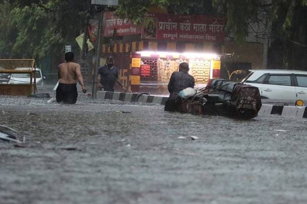 People are seen wading through a waterlogged road amid rains, in New Delhi, Friday morning on June 28, 2024. (Photo source: PTI)