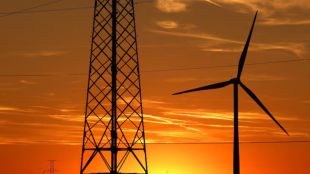 A wind turbine and electrical power pylons of high-tension electricity are pictured in a field near Sint-Pieters-Leeuw, Belgium