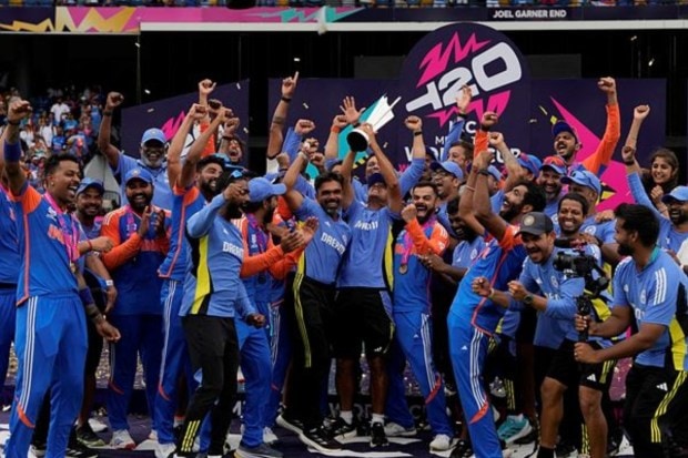Head coach Rahul Dravid, center, and players celebrate with the winners trophy after defeating South Africa. (AP/PTI)