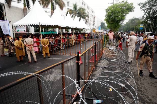 Security personnel stand guard as pilgrims wait to register for the annual Amarnath Yatra at Saraswati Dham Railway Station, in Jammu. (PTI Photo)