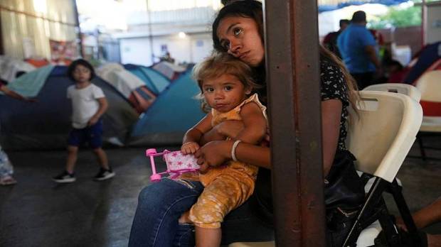 A migrant woman along with her child is watching the live footage of the first US presidential debate in Tijuana, Mexico. (Photo source: Reuters)