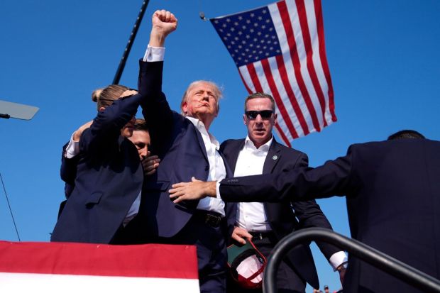 Former President Donald Trump gestures as he is surrounded by U.S. Secret Service agents as he leaves the stage.(Photo: AP/PTI)