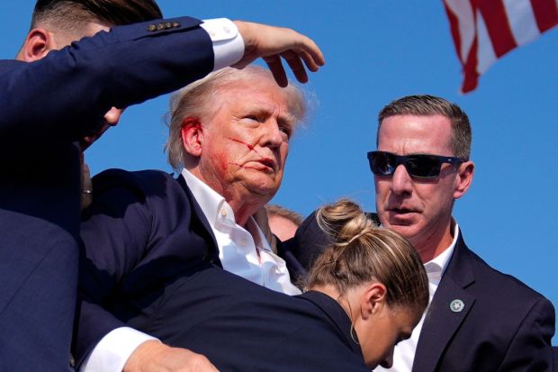 Former President Donald Trump is surrounded by U.S. Secret Service agents as he leaves the stage(Photo: AP/PTI)
