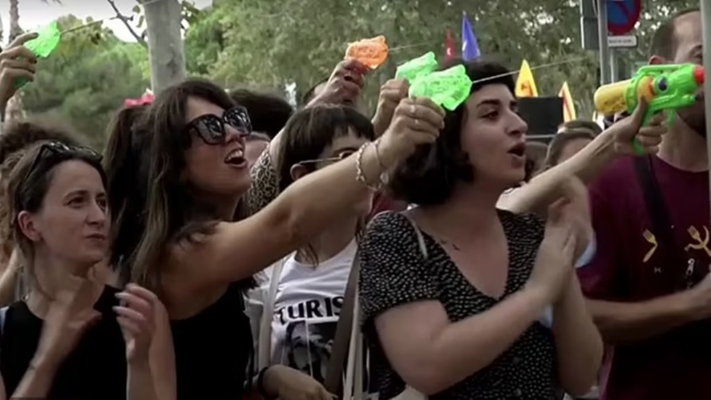 'Barcelona not for sale, tourists go home': Mass tourism protestors squirt water guns at foreigners as living costs spiral