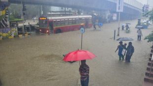 A bus moves on a waterlogged road during monsoon rain