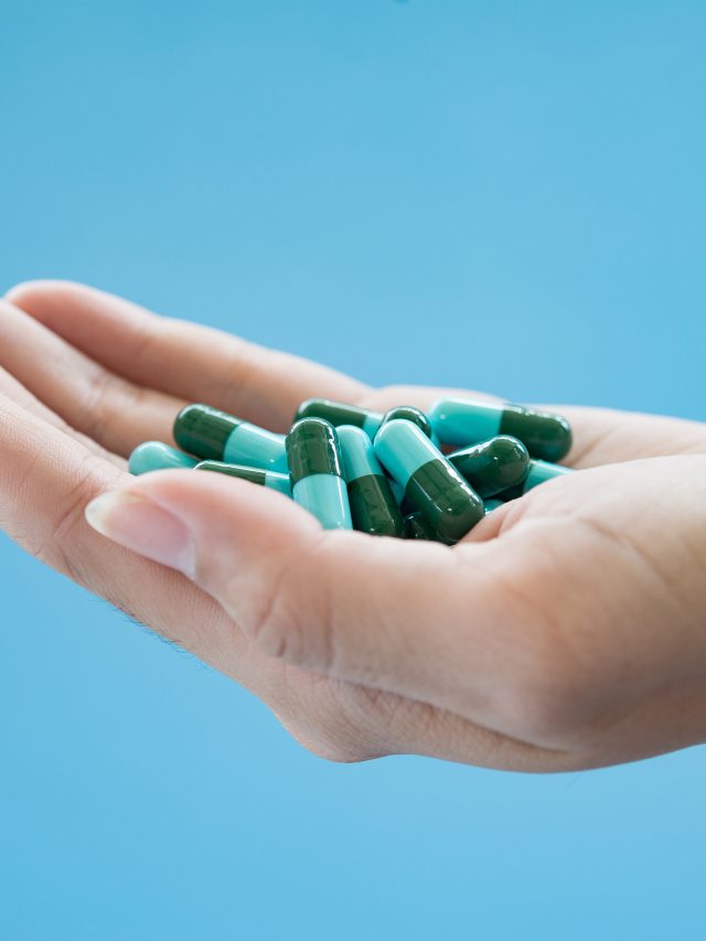 Woman's hand pours the medicine pills out of the bottle