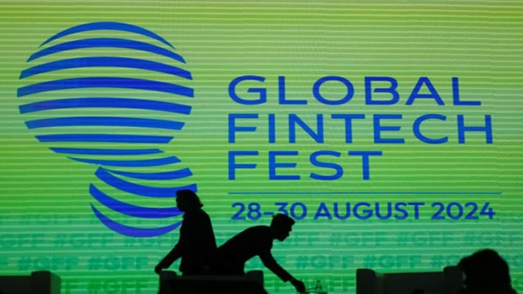 People walk past a logo of the Global Fintech Fest in Mumbai, India, August 28, 2024. REUTERS