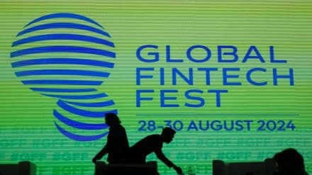 People walk past a logo of the Global Fintech Fest in Mumbai, India, August 28, 2024. REUTERS