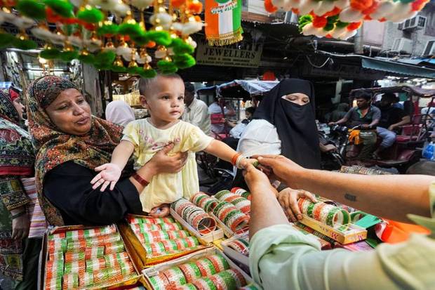 A woman buying tri-coloured bangles for her daughter at a shop in New Delhi. (Photo source: PTI)