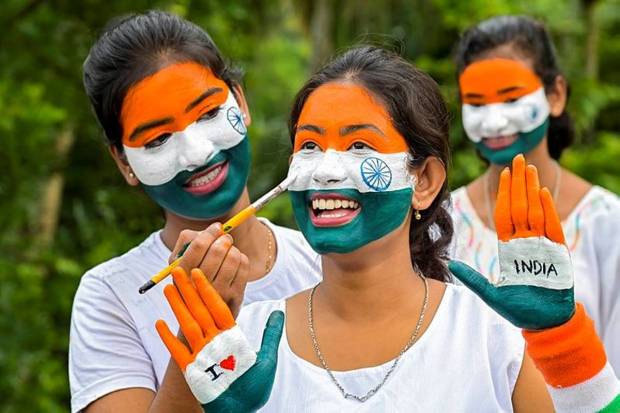 Girls paint their faces in the colour of the Indian National flag during Independence day preparations, in Nadia. (Photo source: PTI)