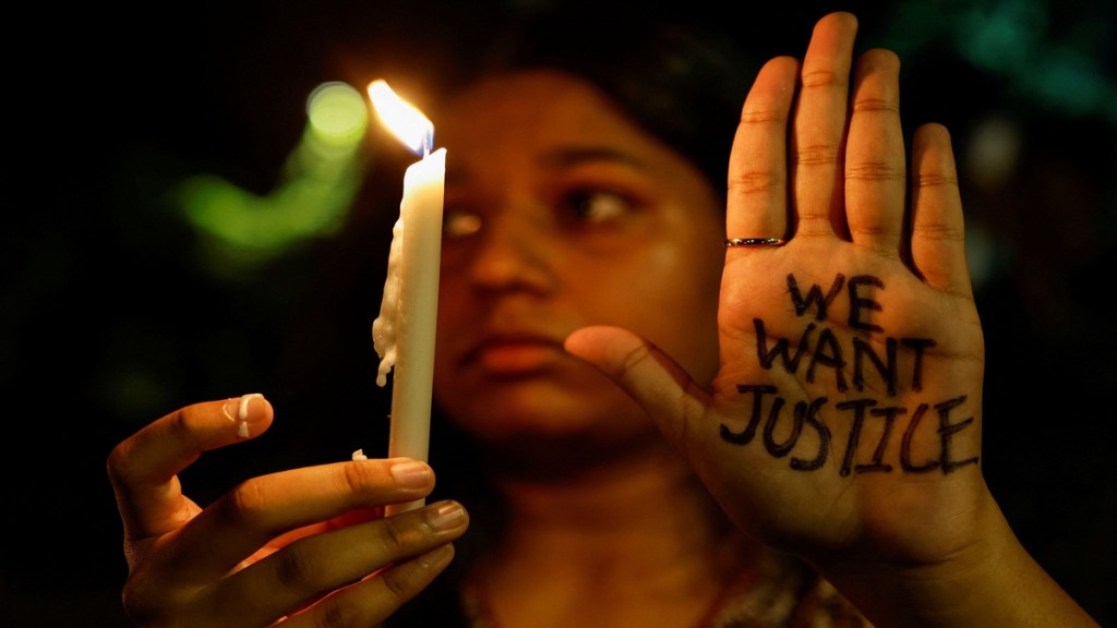 A woman holds a candle during a vigil condemning the rape and murder of a trainee medic at a government-run hospital in Kolkata, on a street in Mumbai, India, August 14, 2024. REUTERS/Francis Mascarenhas