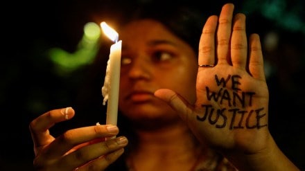 A woman holds a candle during a vigil condemning the rape and murder of a trainee medic at a government-run hospital in Kolkata, on a street in Mumbai, India, August 14, 2024. REUTERS/Francis Mascarenhas