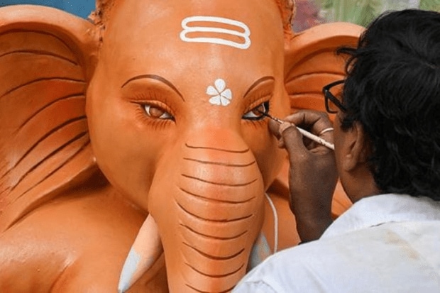 An artisan gives final touches to an idol of Lord Ganesh ahead of the Ganesh Chaturthi festival, in Guwahati. (Photo: PTI)