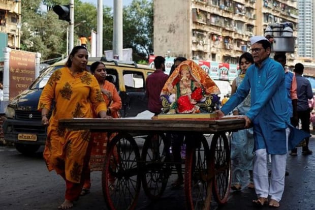 People push a cart carrying an idol of the Hindu god Ganesh on the first day of the ten-day long Ganesh Chaturthi festival, on a street in Mumbai. (Photo: Reuters)