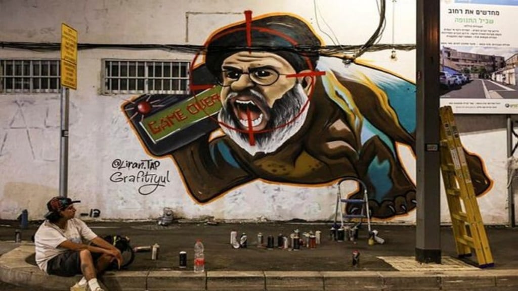 Israeli graffiti artist Maayan, from the Grafitiyul group, rests after she finished working on a graffiti of Hezbollah leader Sayyed Hassan Nasrallah after Israel's military confirmed it had eliminated him in a Beirut airstrike, in Tel Aviv, Israel, September 29, 2024. (REUTERS) Israeli graffiti artist Maayan, from the Grafitiyul group, rests after she finished working on a graffiti of Hezbollah leader Sayyed Hassan Nasrallah after Israel's military confirmed it had eliminated him in a Beirut airstrike, in Tel Aviv, Israel, September 29, 2024. (REUTERS)