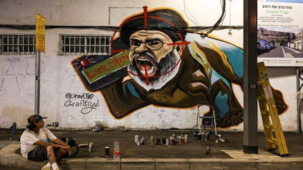 Israeli graffiti artist Maayan, from the Grafitiyul group, rests after she finished working on a graffiti of Hezbollah leader Sayyed Hassan Nasrallah after Israel's military confirmed it had eliminated him in a Beirut airstrike, in Tel Aviv, Israel, September 29, 2024. (REUTERS)
