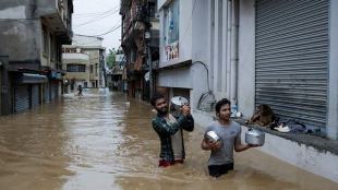 People wade through a flooded road near the bank of the overflowing Bagmati River following heavy rains, in Kathmandu, Nepal September 28, 2024. (REUTERS)