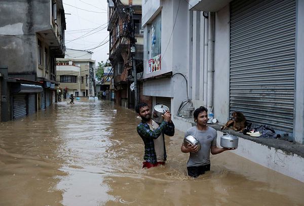 People wade through a flooded road near the bank of the overflowing Bagmati River following heavy rains, in Kathmandu, Nepal September 28, 2024. (REUTERS)
