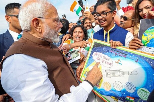 When Prime Minister Narendra Modi landed at Philadelphia airport on Saturday, he was greeted by members of the Indian community in the United States. Here, a student is showing his 'Chandraayan' painting to the PM. (PTI Photo)
