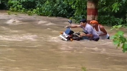 Commuters wade through a flooded area after an increase in the water level of Gandak river due to heavy rainfall, in Bagaha, Bihar, Saturday, Sept 28, 2024. (PTI Photo)
