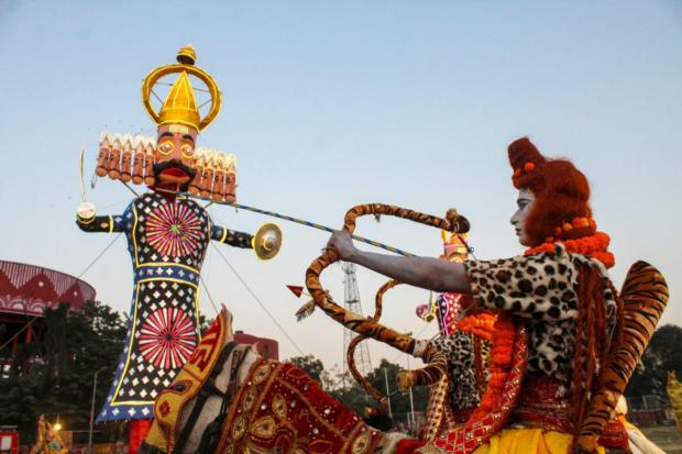 An artist posing in front of demon king Ravan's effigy during the Dussehra celebration in Dehradun.