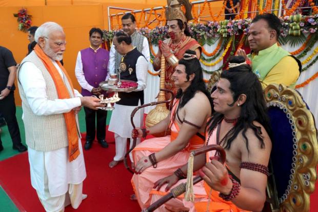 Prime Minister Narendra Modi offers prayers before artists dressed as Lord Rama, Lakshmana and Hanumana during Dussehra celebration, at Red Fort in Delhi.
