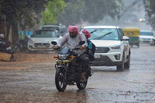 People commute amid rains because of ‘Spawn’ cyclone, in Bengaluru. (Photo source: PTI)