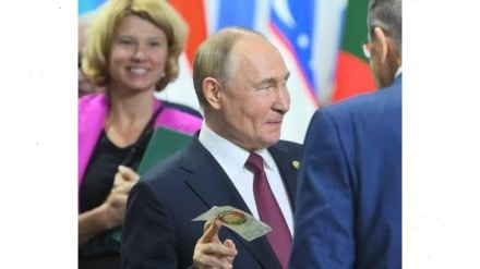Putin holding the symbolic BRICS bank note at Kazan