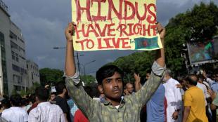 A demonstrator displays a placard during a protest , in Dhaka, Bangladesh, on August 9, 2024. Representational Photo/(Image Source: Reuters)