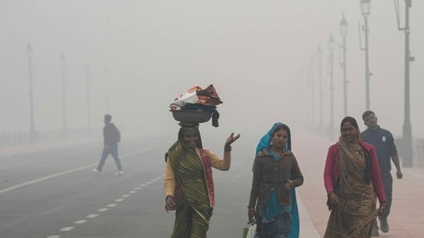 Labourers make their way along the Kartavya Path shrouded in thick smog, as air quality in New Delhi stays in the 'severe' category with low visibility. (PTI)