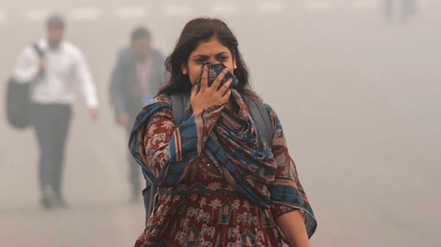 Commuters head to their offices through dense smog, as air quality remains in the 'severe' category with low visibility. (PTI)