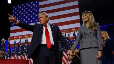 Republican presidential nominee and former U.S. President Donald Trump gestures as he holds hands with his wife Melania during his rally, at the Palm Beach County Convention Center in West Palm Beach, Florida, U.S., November 6, 2024. REUTERS/Brian Snyder