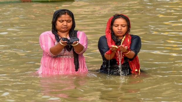 Devotees offer prayers as they take a holy dip in the Ganga River during the 'Nahay Khay' ritual of the Chhath Puja festival in Patna. (Image:PTI)