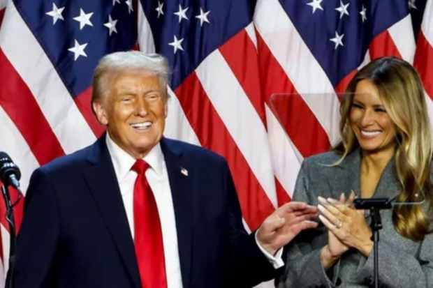Republican presidential nominee former President Donald Trump waves as he walks with former first lady Melania Trump at an election night watch party at the Palm Beach Convention Center, Wednesday, Nov. 6, 2024, in West Palm Beach, Fla. (AP Photo/Evan Vucci)