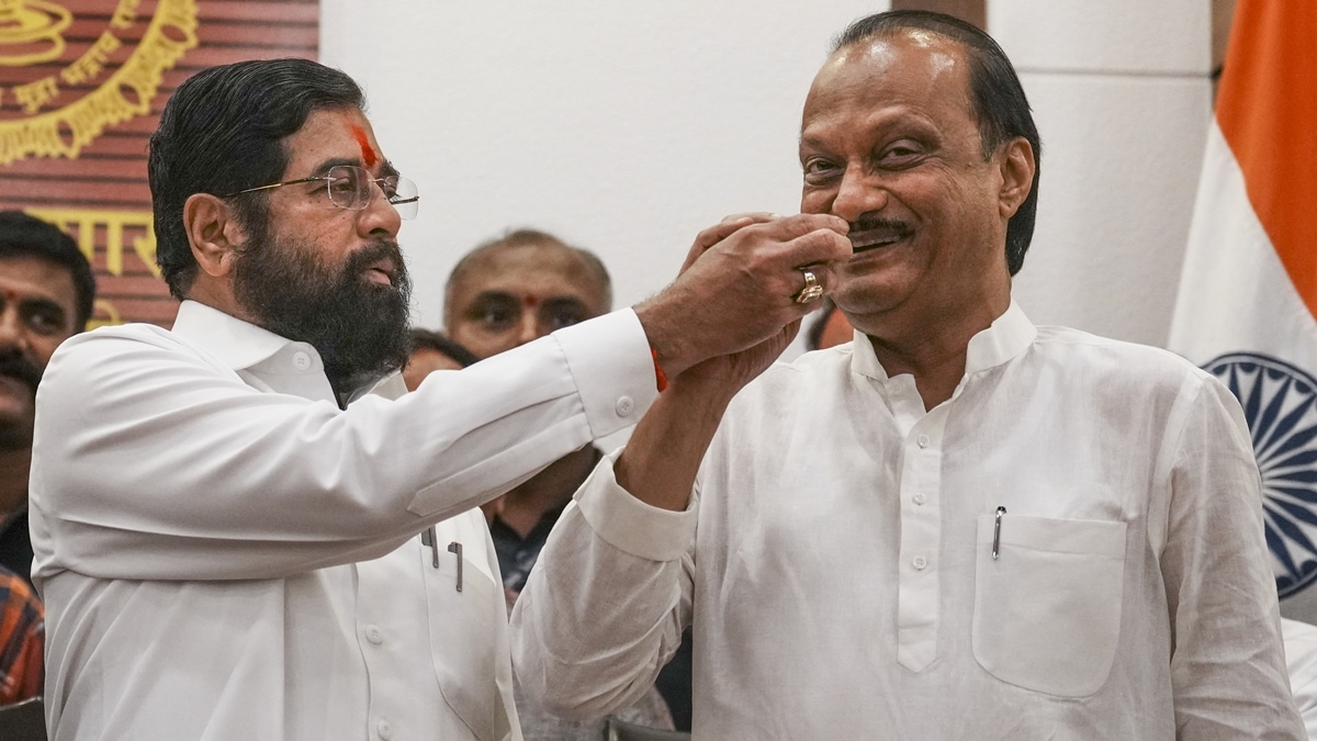 Maharashtra Chief Minister Eknath Shinde with Deputy Chief Minister Ajit Pawar celebrates during a press conference as the BJP-led Mahayuti alliance secures victory amid the counting of votes for the Maharashtra Assembly elections, in Mumbai, Saturday, Nov. 23, 2024. (PTI Photo/Kunal Patil)