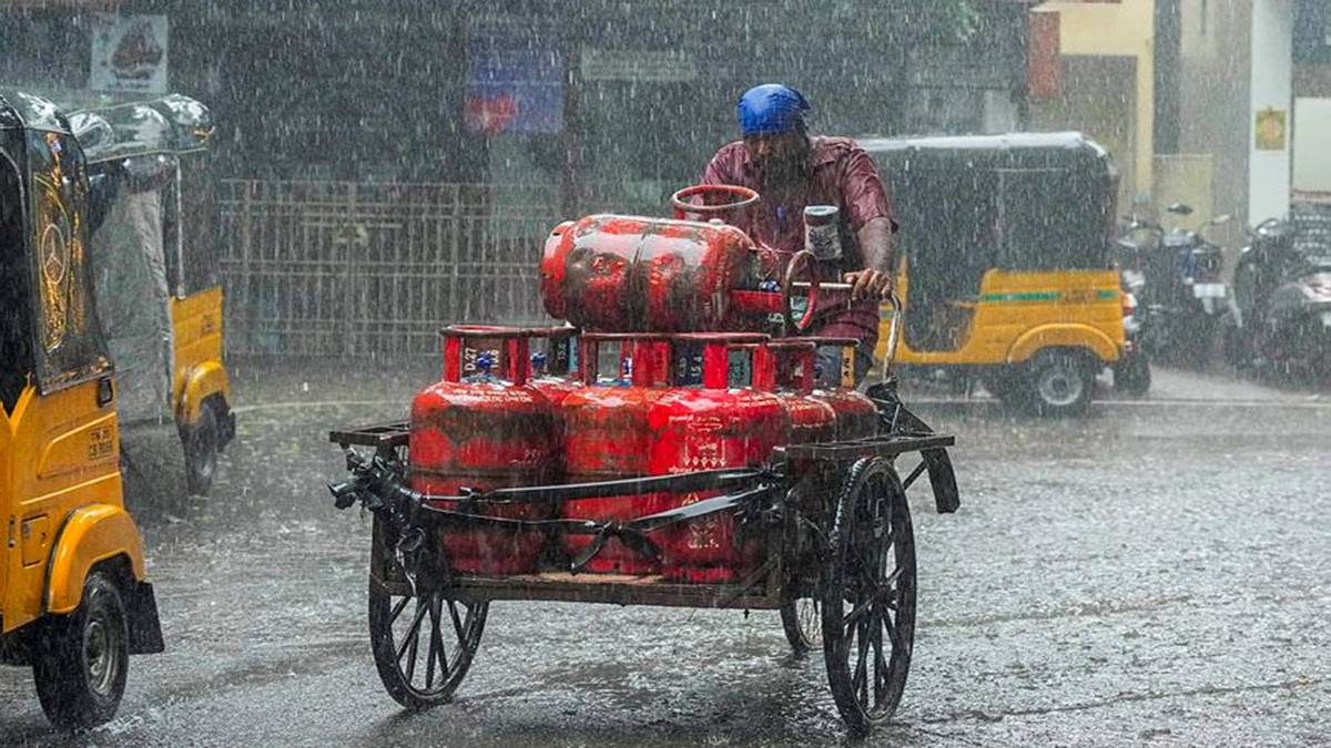 An LPG cylinder delivery man caught in a sudden rain, in Chennai. (Photo source: PTI)