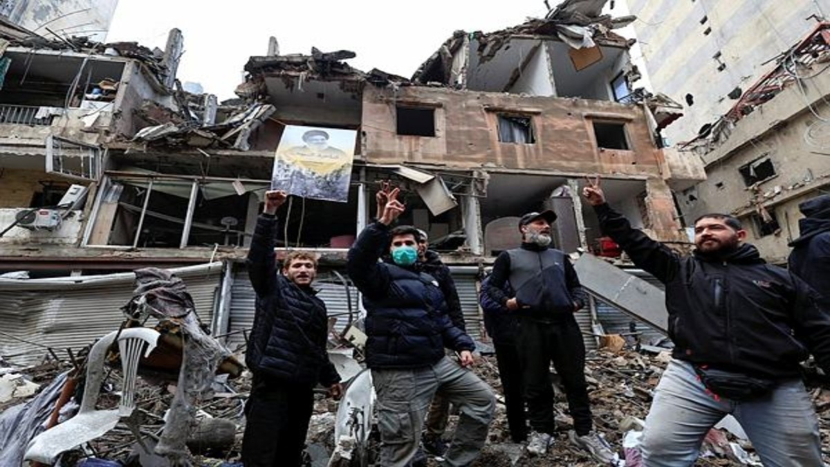Men gesture infront of buildings damaged in Israeli strikes in Beirut's southern suburbs, after a ceasefire between Israel and Iran-backed group Hezbollah took effect at 0200 GMT on Wednesday after U.S. President Joe Biden said both sides accepted an agreement brokered by the United States and France, in Lebanon, November 27, 2024. REUTERS