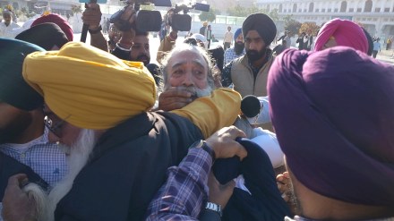 People catch a man, center, who allegedly opened fire at Shiromani Akali Dal leader Sukhbir Singh Badal while the latter was performing the duty of 'sewadar' outside the Golden Temple, in Amritsar, Wednesday, Dec. 4, 2024. (PTI Photo)