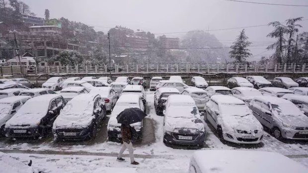 Cars are covered in a thick layer of snow, creating a quiet, wintery scene as the snow continues to blanket the vehicles, transforming them into white sculptures amid the chilly landscape. (PTI Photo)