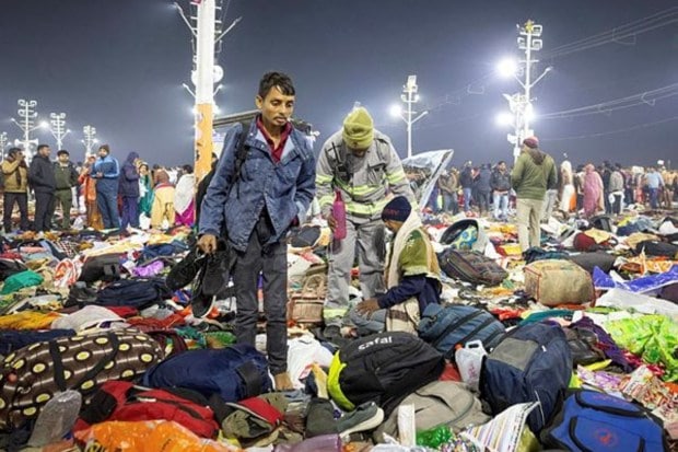 A policeman assists an injured person following a stampede before the second 
