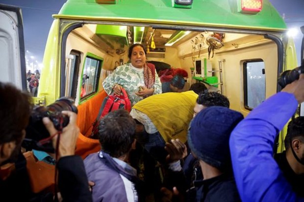 A relative of an injured person stands inside an ambulance following a deadly stampede before the second 
