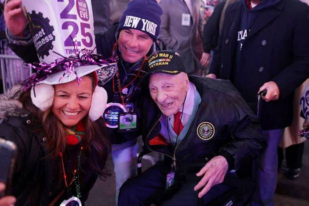 Dominick Critelli, a 103-year-old World War II veteran takes a picture with revellers as people gather at Times Square to watch the ball drop on New Year's Eve in New York City, US. (Photo source: Reuters)
