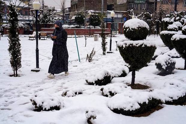 A pedestrian at a snow-covered park after fresh snowfall, in Srinagar. (Photo source: PTI)