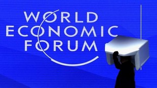 A staff member carries an armchair during the preparation of the plenary room ahead of the World Economic Forum (WEF) in Davos, Switzerland January 18, 2025. REUTERS/Yves Herman.