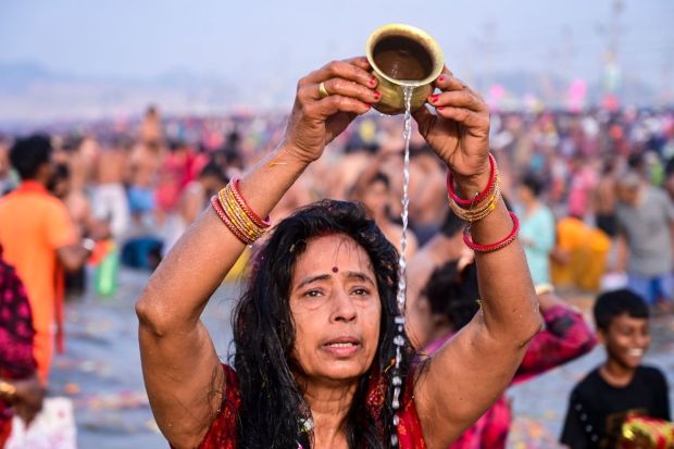 A devotee offering 'jal' as part of her prayers on the Maha Shivratri shahi-snan on the last day of the Kumbh Mela 2025. (Image: PTI)