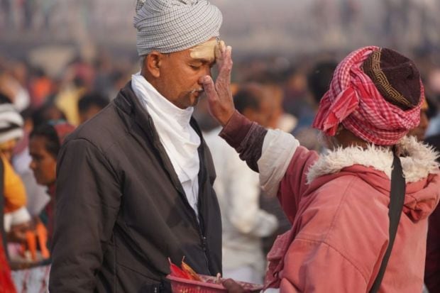 A source of livelihood for many, people apply 'tika' on the foreheads of devotees after taking a holy dip in the Ganga river, (Image: PTI)