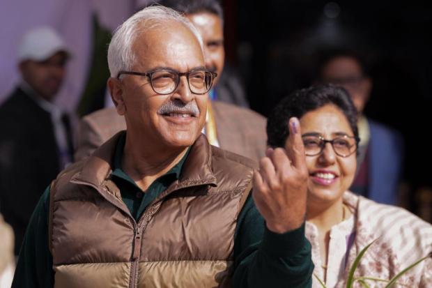 Manipur Governor Ajay Kumar Bhalla shows his finger marked with indelible ink after casting vote during the Delhi Assembly elections.